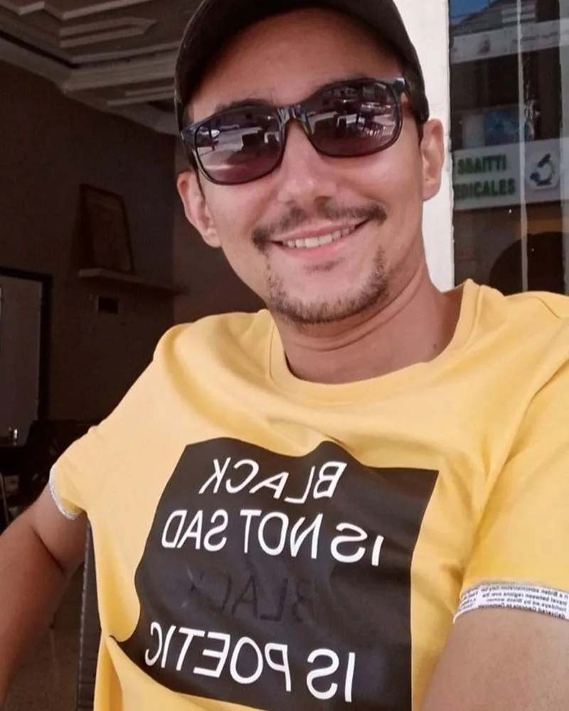 Jocker Wink smiling backstage with sunglasses and a cap
